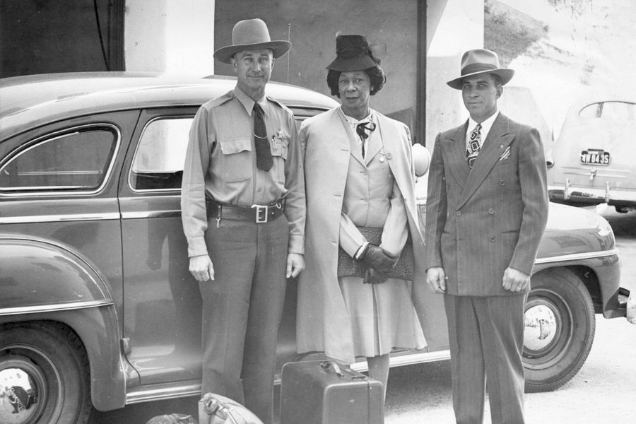 Lucy Hicks Anderson stands with deputies H.E. Bowman and Charles Salig near a car in Ventura County, likely during her 1945 arrest.