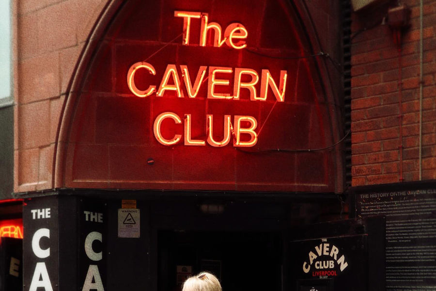 Entrance of The Cavern Club in Liverpool with its glowing red neon sign, a historic site in UK music history.