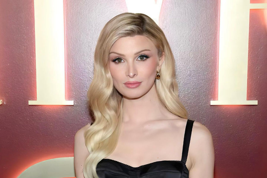 Dylan Mulvaney posing in a black Dolce & Gabbana dress at Vanity Fair x Meta event in March 2024.