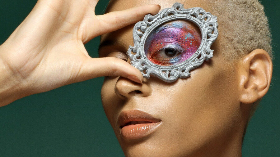 Close-up of Isis King holding a small ornate frame over her eye, featured in Basic Magazine, February 2017.