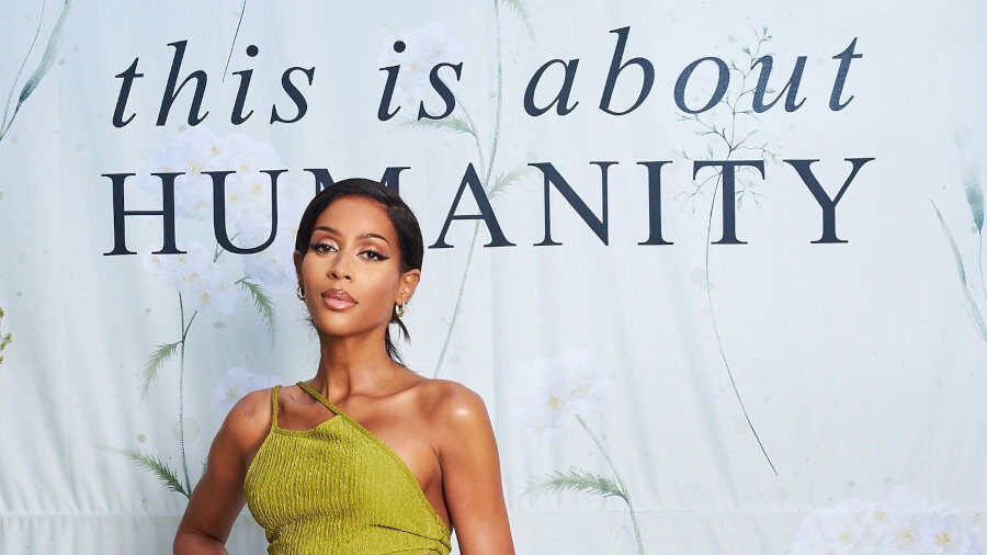 Isis King posant en robe verte asymétrique devant un fond portant l’inscription “This Is About Humanity”, août 2025.