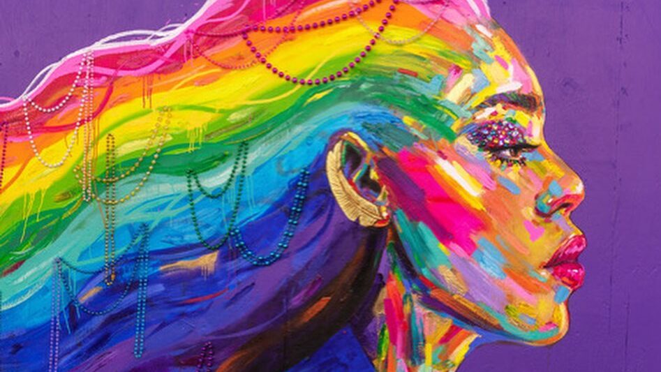 Une fresque vibrante de Laverne Cox peinte dans des tons arc-en-ciel sur un fond violet. Ses longs cheveux forment des vagues colorées ornées de perles. Ce portrait a été réalisé par l’artiste Kate Tova à l’occasion du Spirit Day, symbolisant force, fierté et solidarité avec les jeunes LGBTQ+.