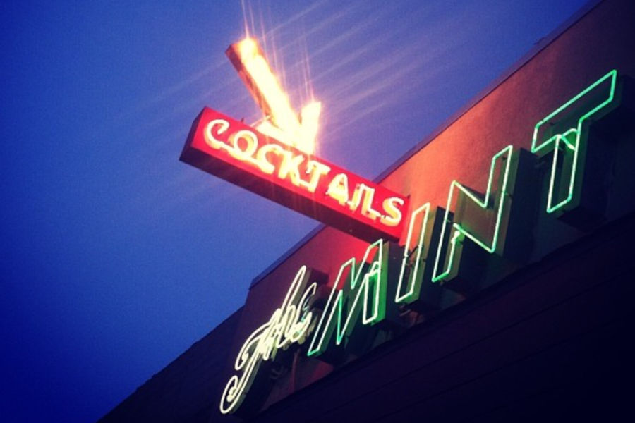 Neon sign of The Mint Bar in Bakersfield glowing at night with “Cocktails” and “Mint” in red and green lights.
