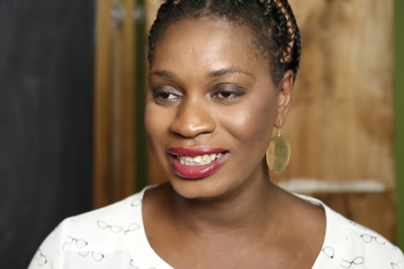 Monica Jones speaking in a TV interview on The Laura Flanders Show in 2015, wearing white with braided hair.