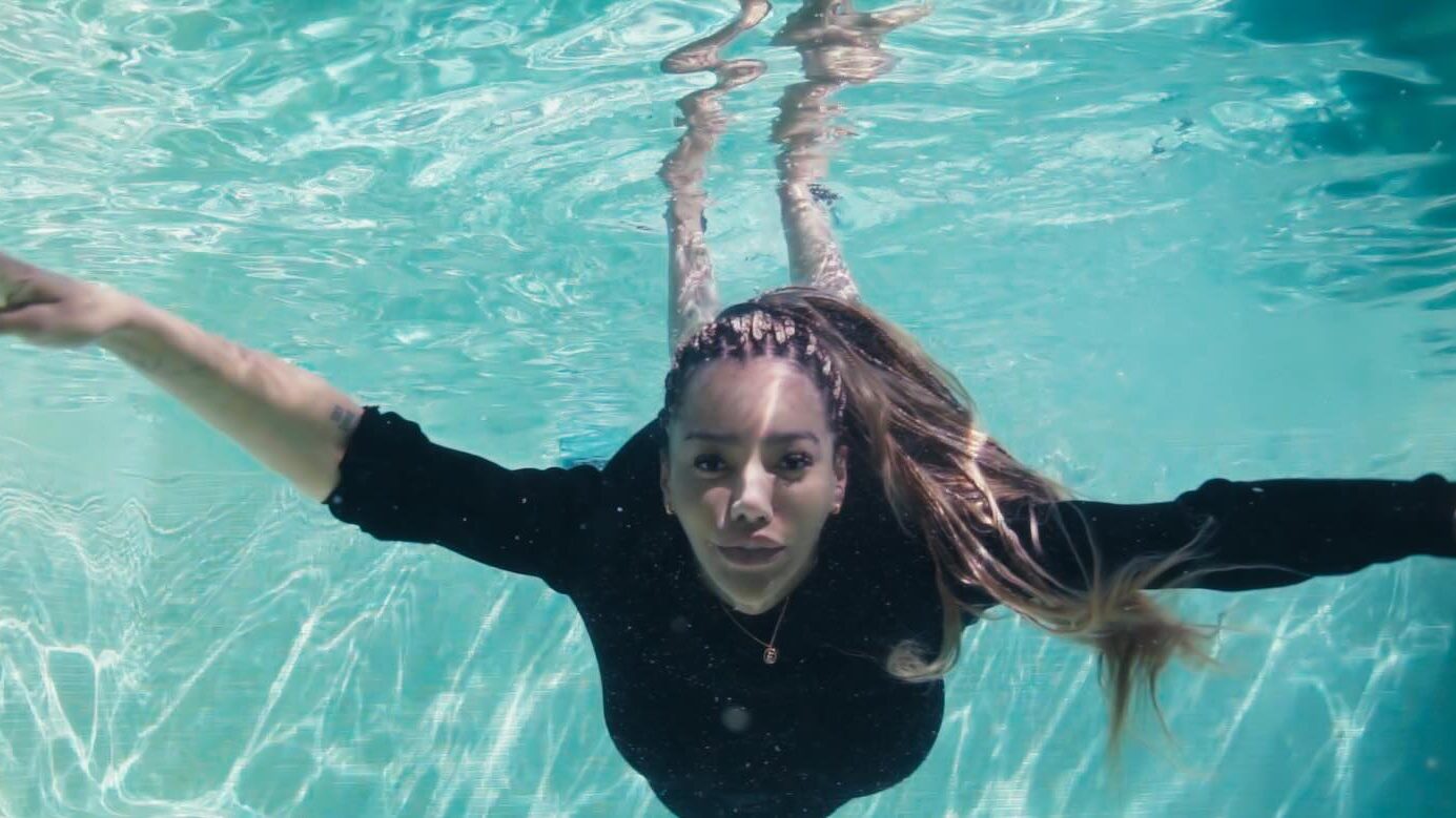 Image promotionnelle de Munroe Bergdorf sous l’eau, les bras étendus.