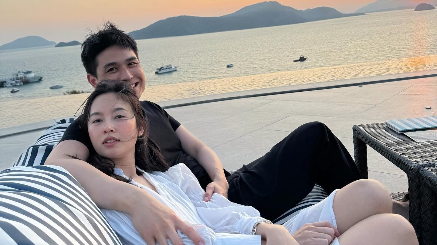 Nong Poy et son mari enlacés au bord de la mer au coucher du soleil.