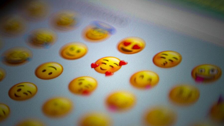 A glowing view of a digital emoji panel, highlighting the affectionate smiling emoji surrounded by others.