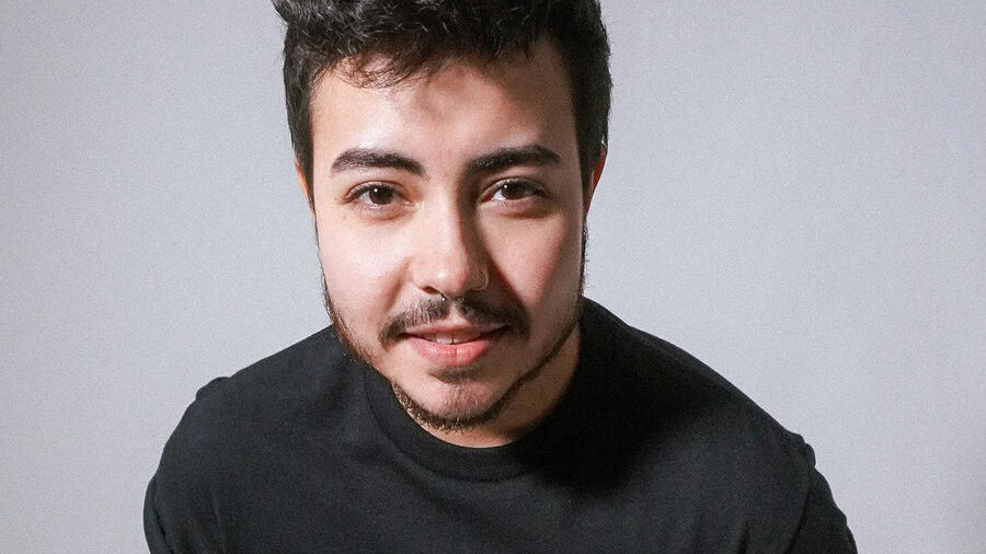 Leo Sheng facing camera, smiling, wearing a black “Vote Trans” T-shirt.