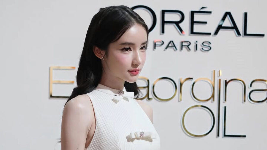 Yoshi Rinrada standing in front of a L’Oréal backdrop during a brand campaign shoot.